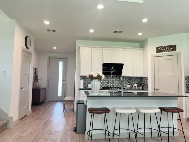 a kitchen with stainless steel appliances granite countertop a stove a sink and a refrigerator