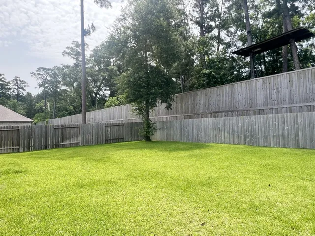 a view of a backyard with a small cabin and a wooden fence
