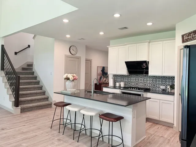 a kitchen with stainless steel appliances kitchen island granite countertop a stove a sink and a microwave