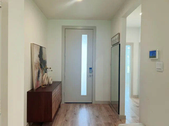 a view of a hallway with wooden floor and closet
