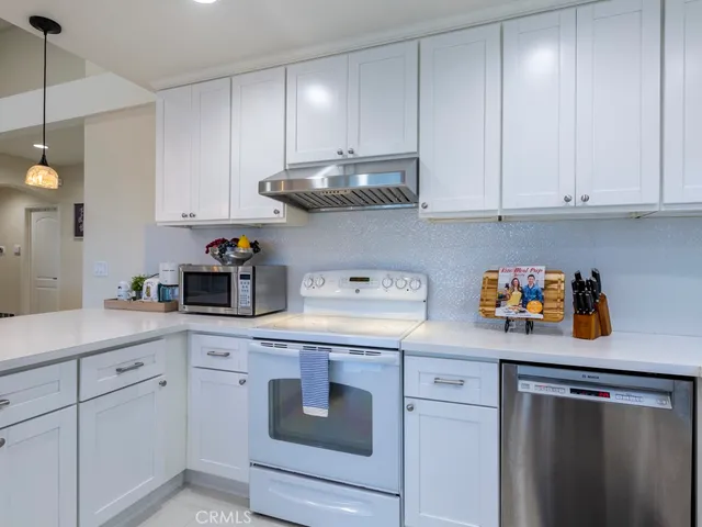 a kitchen with stainless steel appliances granite countertop a sink a stove and cabinets
