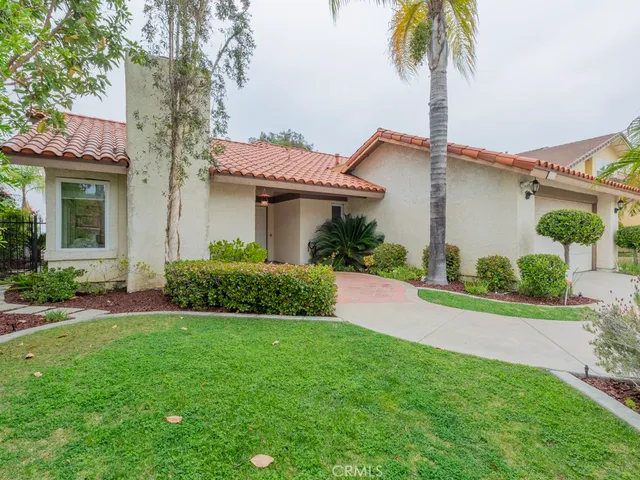 a front view of a house with a garden and plants