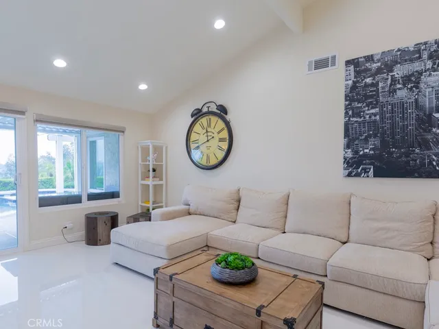a living room with furniture a clock and a window