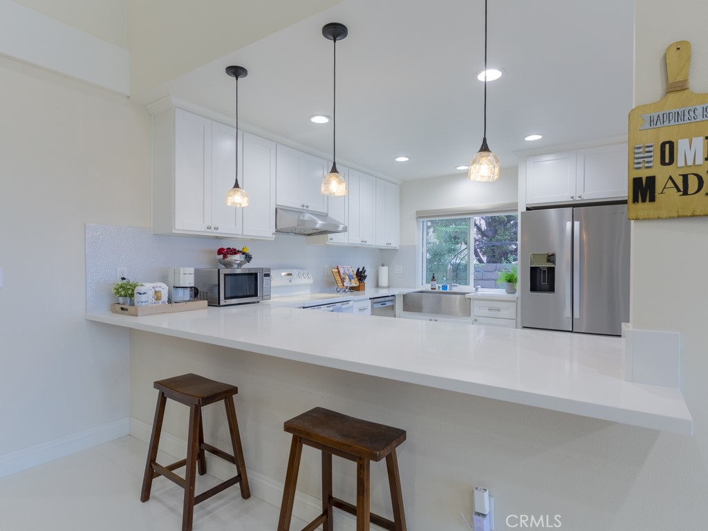 3305 Hawkwood Road Diamond Bar, CA 91765 - Photo 8 of 32 a kitchen with stainless steel appliances granite countertop a sink a refrigerator and a counter top space