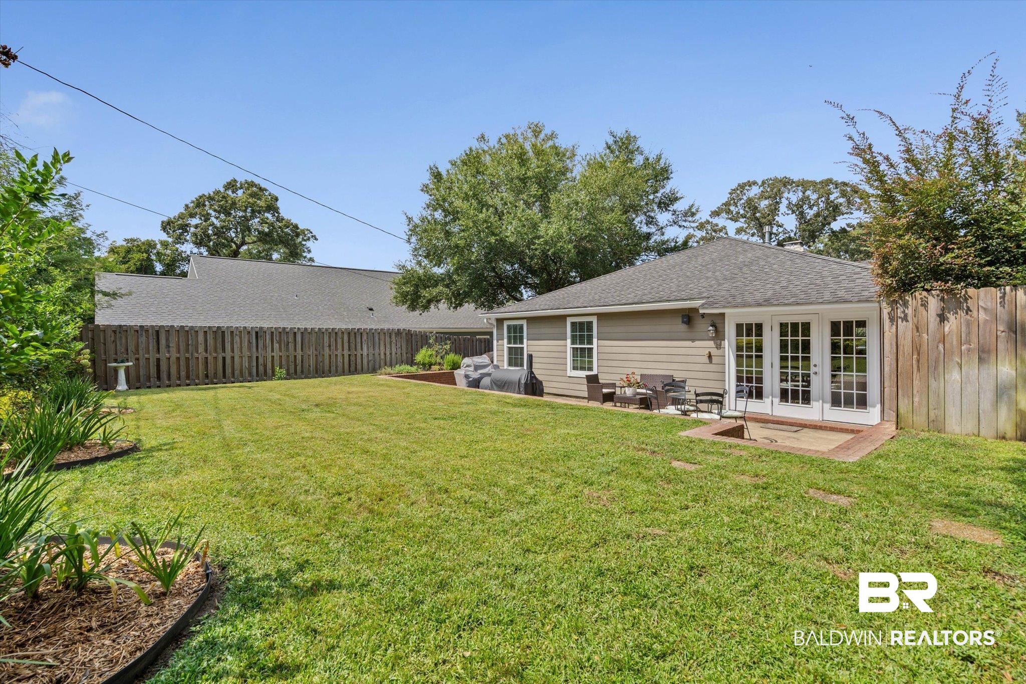77 North Hathaway Road Mobile, AL 36608 - Photo 26 of 33 Fenced backyard with french doors, a patio area, and an outdoor hangout area