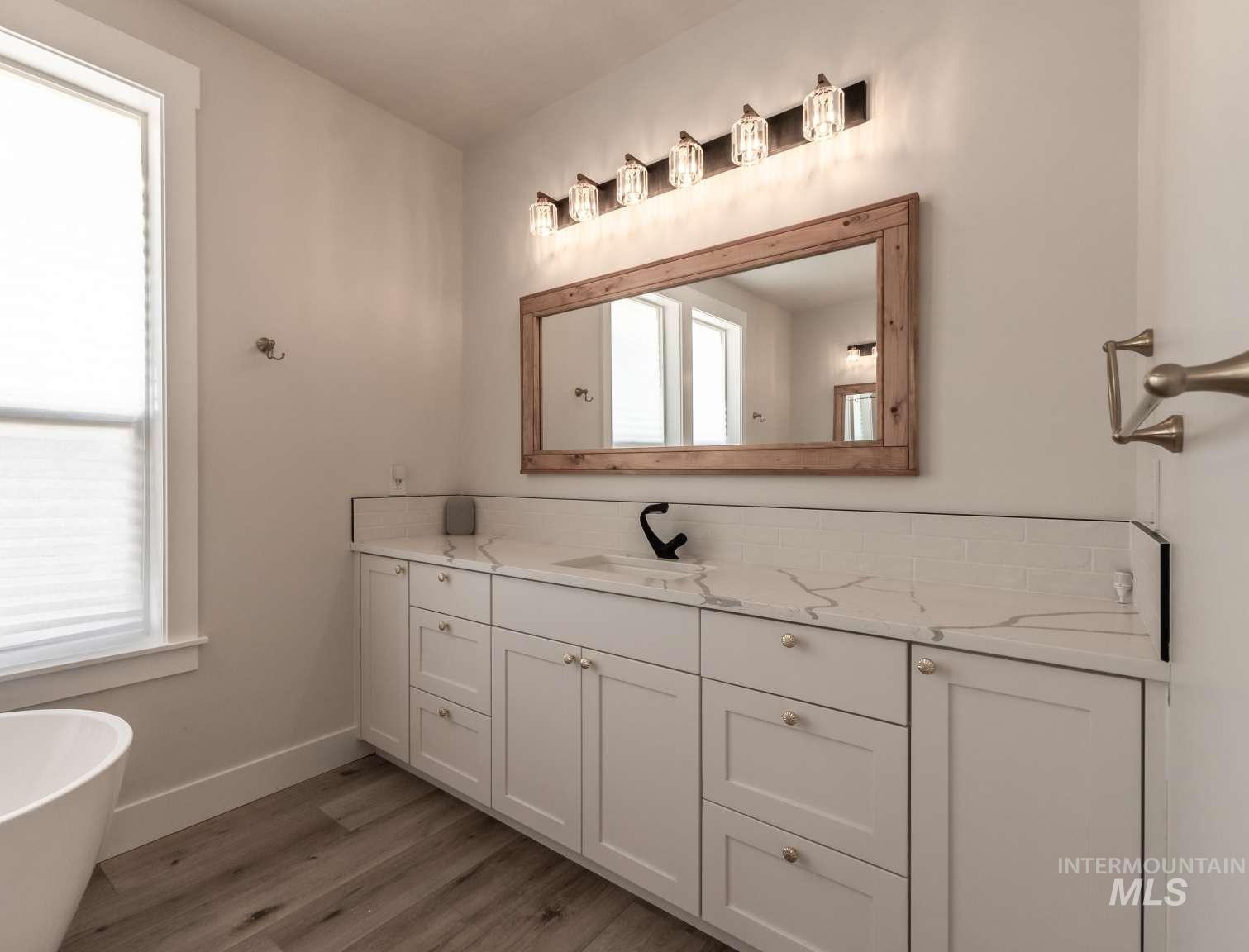 9853 Salmon Ridge Place Nampa, ID 83686 - Photo 15 of 48 Full bath featuring vanity, light wood finished floors, and a freestanding bath