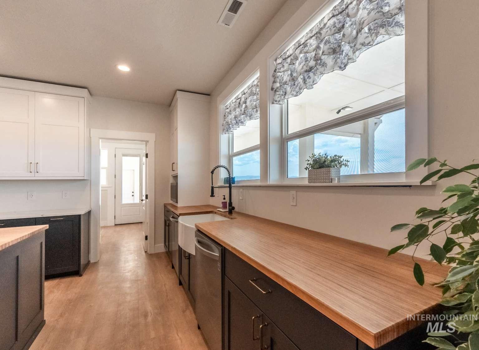 9853 Salmon Ridge Place Nampa, ID 83686 - Photo 28 of 48 Kitchen with dual tone cabinets, stainless steel dishwasher, recessed lighting, and light wood-style flooring