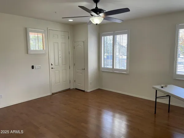 a view of an empty room with a window and wooden floor