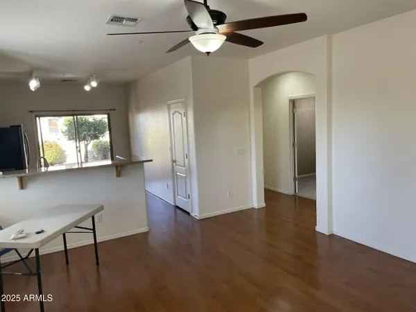 a view of an empty room with window and wooden floor