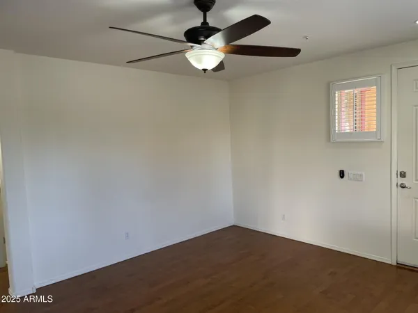 an empty room with a window and a ceiling fan