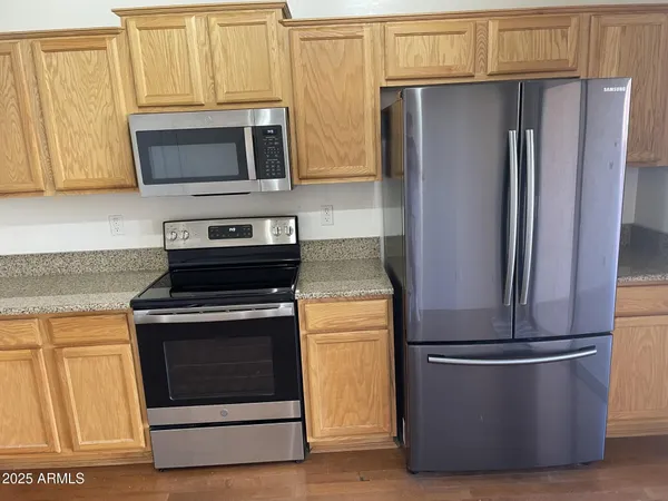a kitchen with stainless steel appliances granite countertop a refrigerator stove and microwave