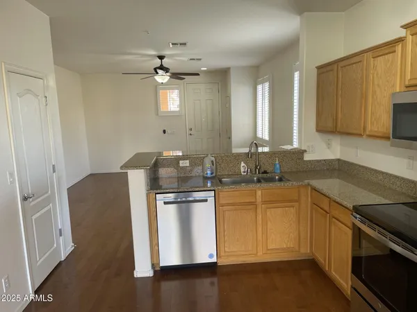 a kitchen with stainless steel appliances granite countertop a sink stove and refrigerator