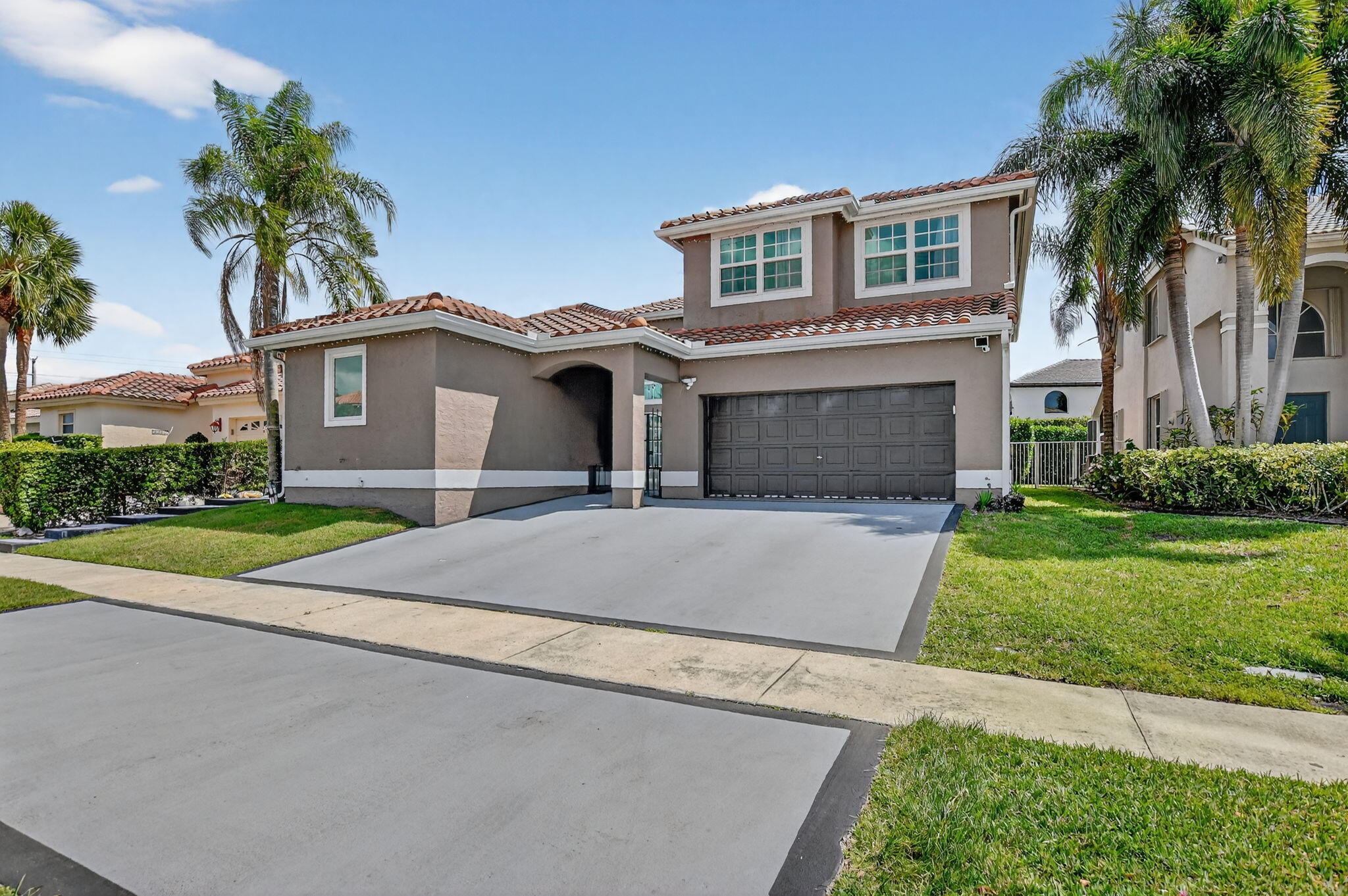 11038 Baybreeze Way Boca Raton, FL 33428 - Photo 5 of 95 a front view of a house with a yard and garage