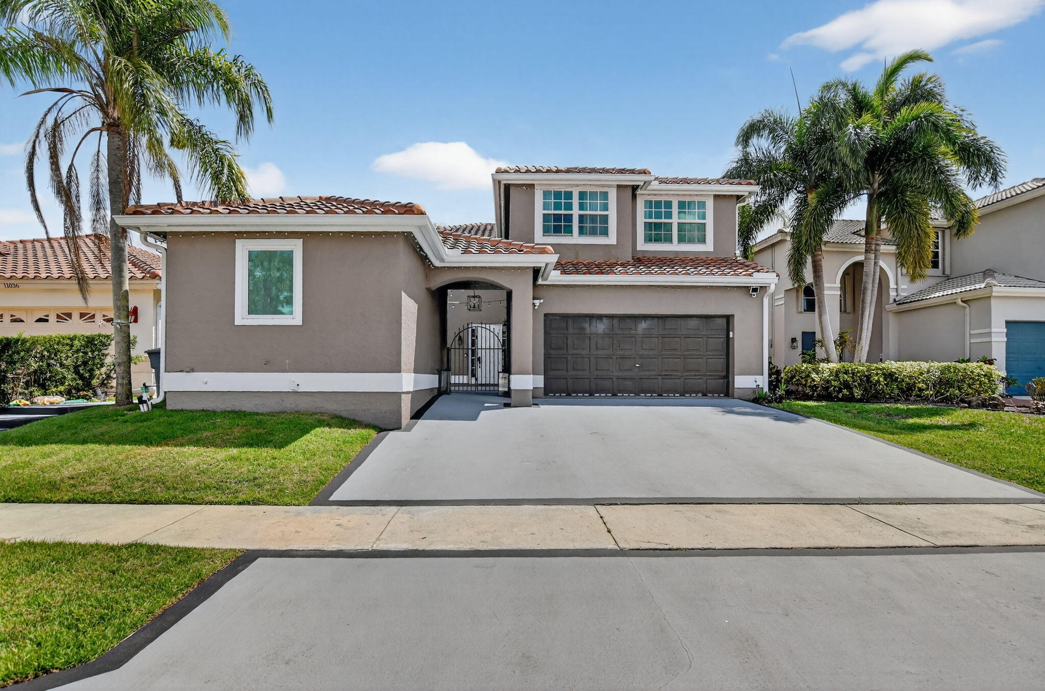 11038 Baybreeze Way Boca Raton, FL 33428 - Photo 6 of 95 a front view of a house with a yard and garage