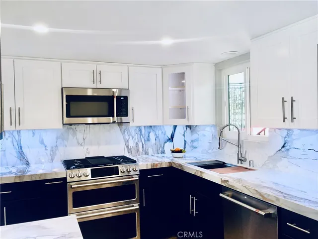a kitchen with a sink and stainless steel appliances