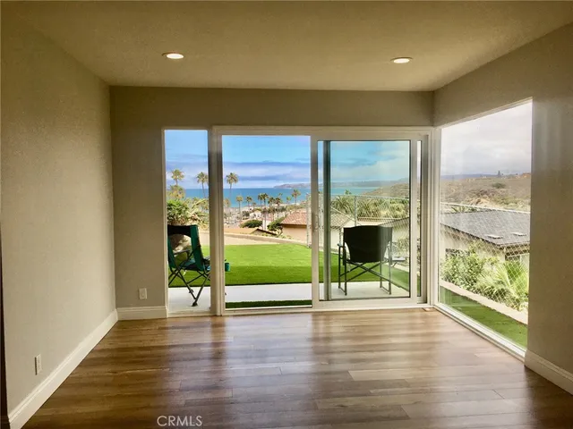 a view of room with wooden floor and windows