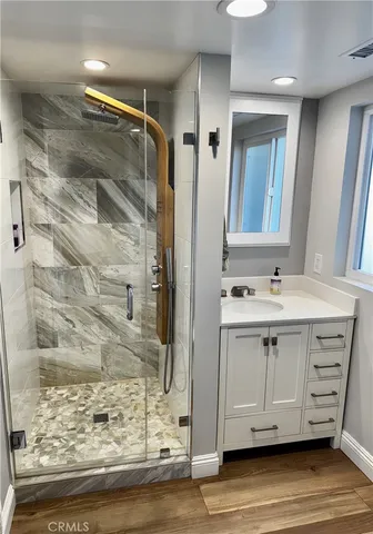 a bathroom with a sink vanity and shower