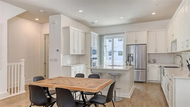 a kitchen with stainless steel appliances kitchen island granite countertop a refrigerator and a stove top oven