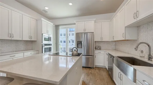 a kitchen with stainless steel appliances granite countertop a sink a stove and a refrigerator