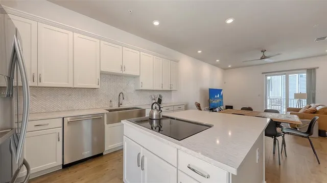 a kitchen with a sink white cabinets and stainless steel appliances