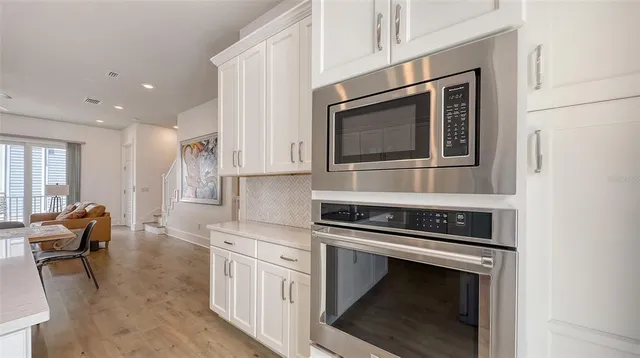 a kitchen with granite countertop a stove and white cabinets