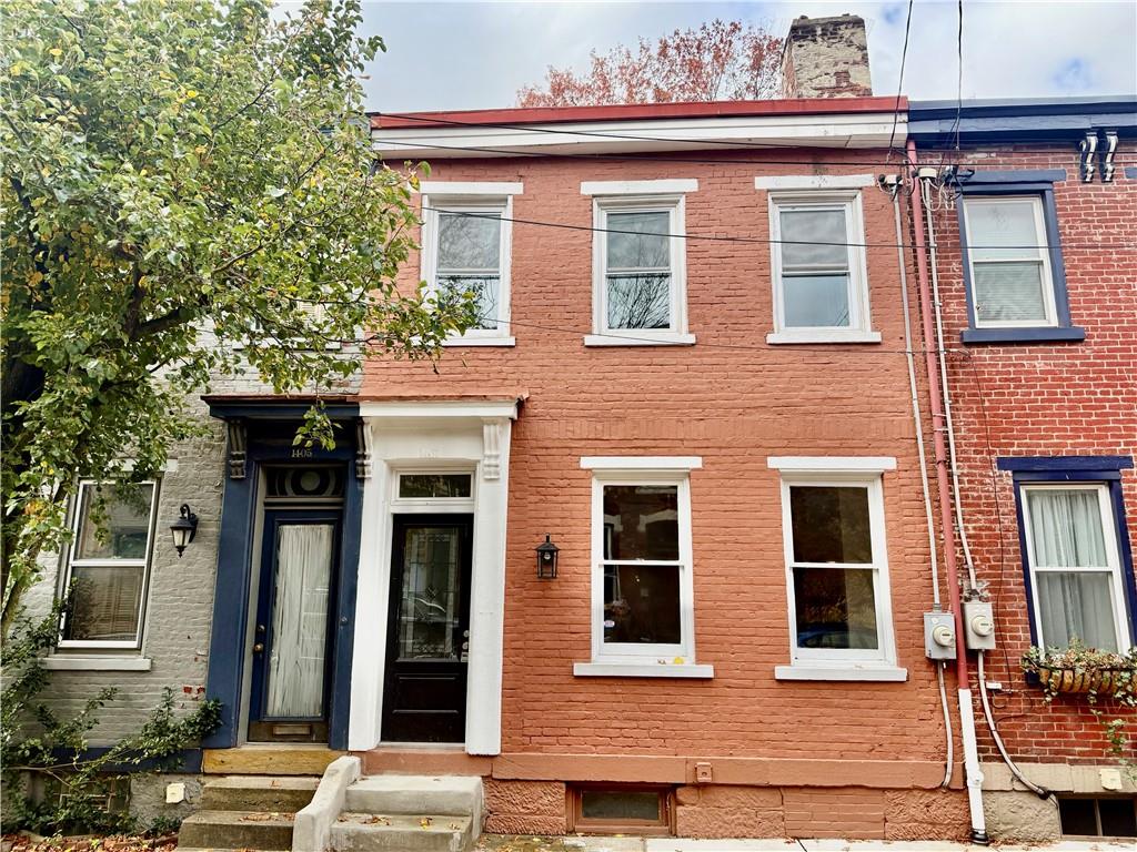front view of a brick house with a large window