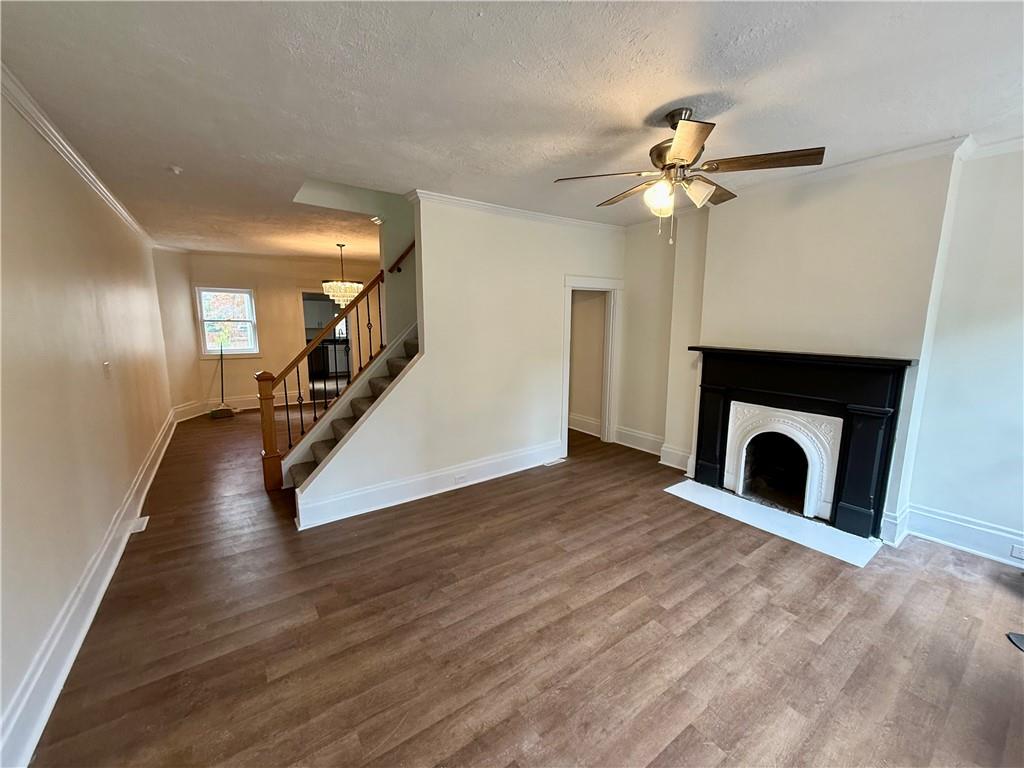 1407 Monterey Street Pittsburgh, PA 15212 - Photo 2 of 16 a view of a livingroom with wooden floor a ceiling fan and a fireplace