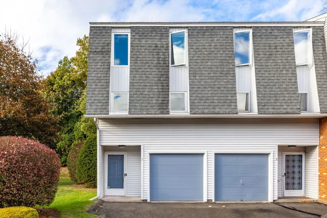 a view of a house with a yard and large tree