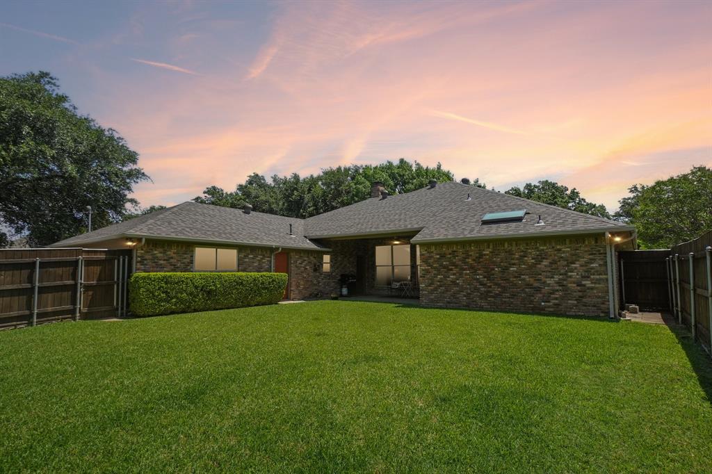12929 Jasoncrest Trail Dallas, TX 75243 - Photo 37 of 38 Expansive green lawn with a mature hedge, surrounded by a wood privacy fence