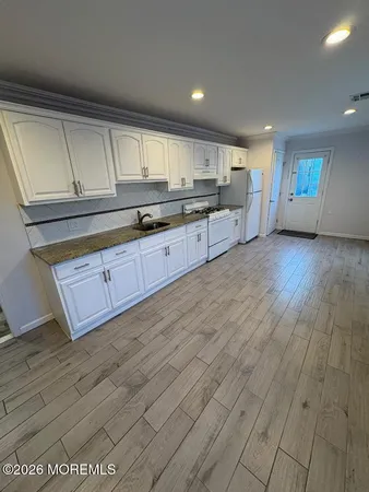 a large kitchen with stainless steel appliances granite countertop a sink and cabinets