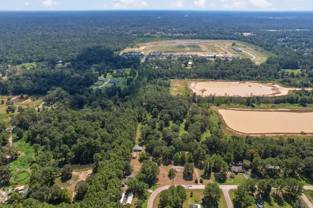 an aerial view of residential houses with outdoor space and lake view