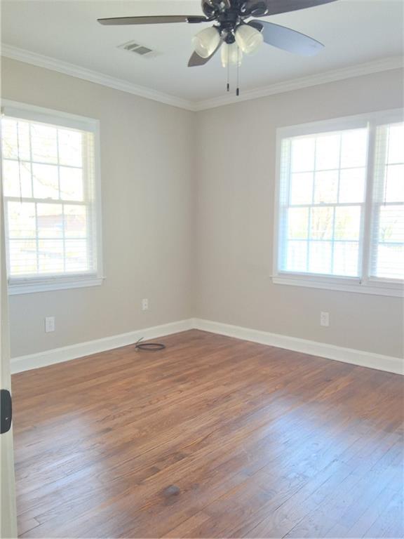 217 Bellview Street Winder, GA 30680 - Photo 8 of 10 an empty room with wooden floor chandelier fan and windows