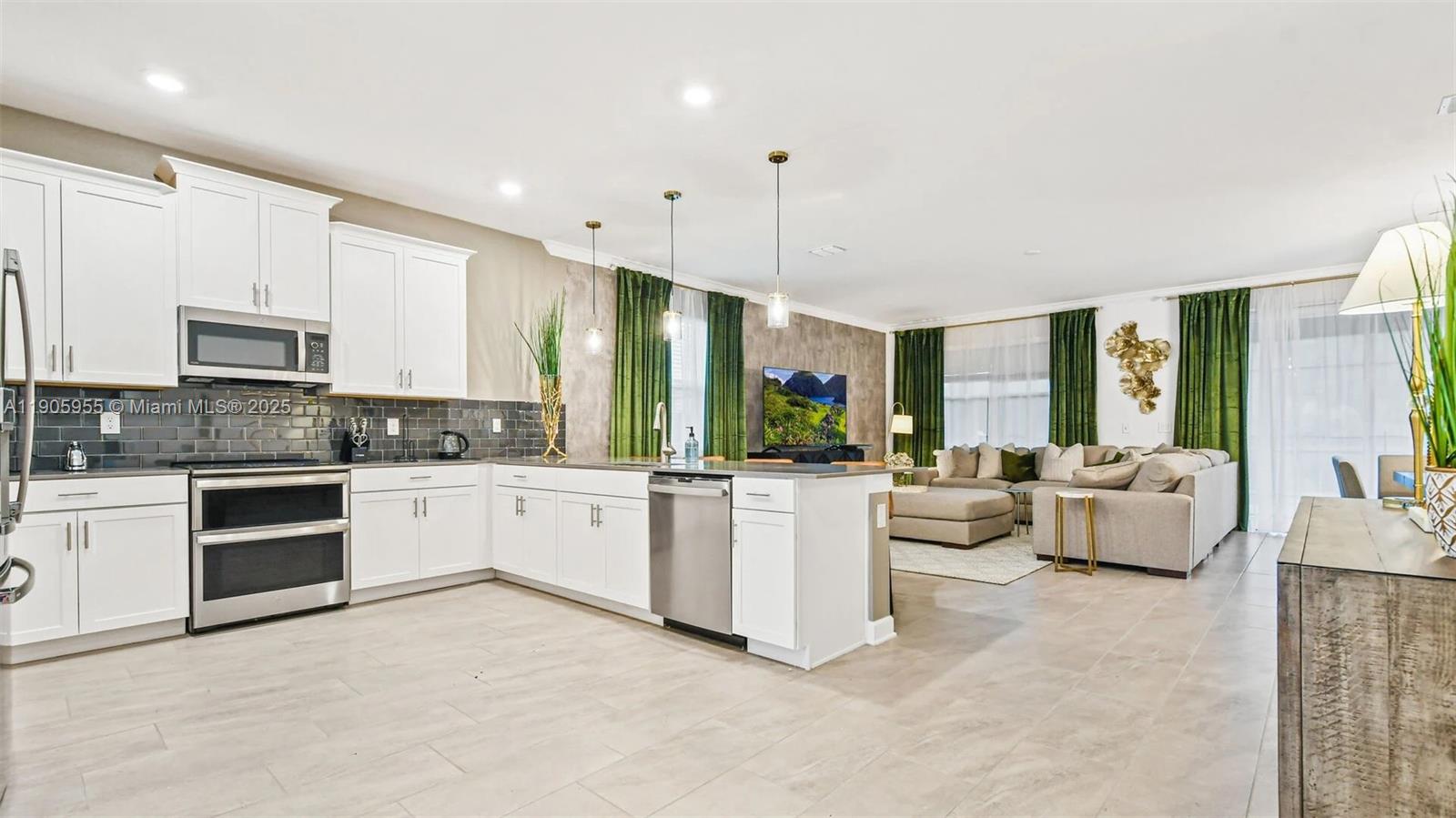 2993 Protagonist Street Kissimmee, FL 34746 - Photo 6 of 31 a large white kitchen with a large window and stainless steel appliances