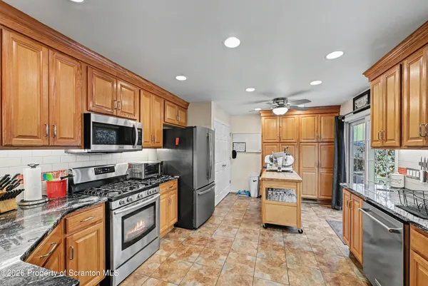a kitchen with granite countertop a refrigerator stove top oven and sink