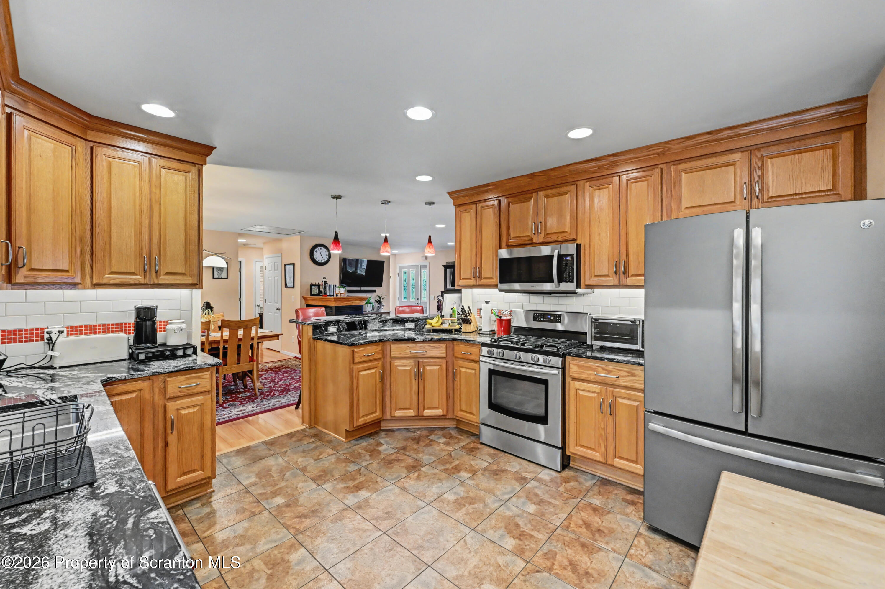 131 Front Street Jessup, PA 18434 - Photo 22 of 58 a kitchen with granite countertop a refrigerator stove top oven and sink
