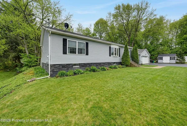 a house is sitting in middle od the grass