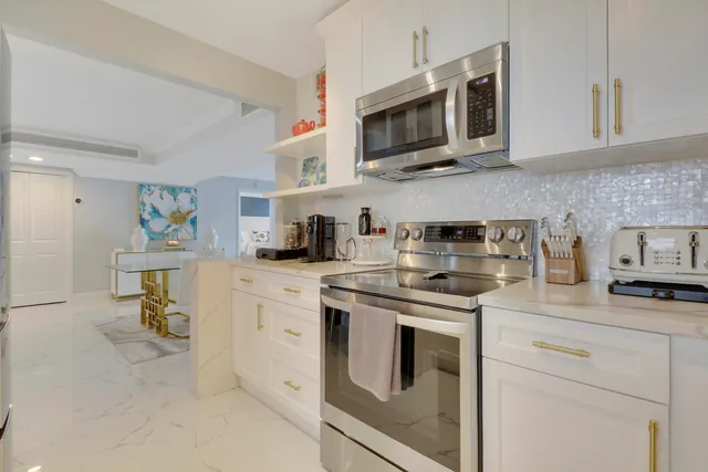 a kitchen with white cabinets and appliances