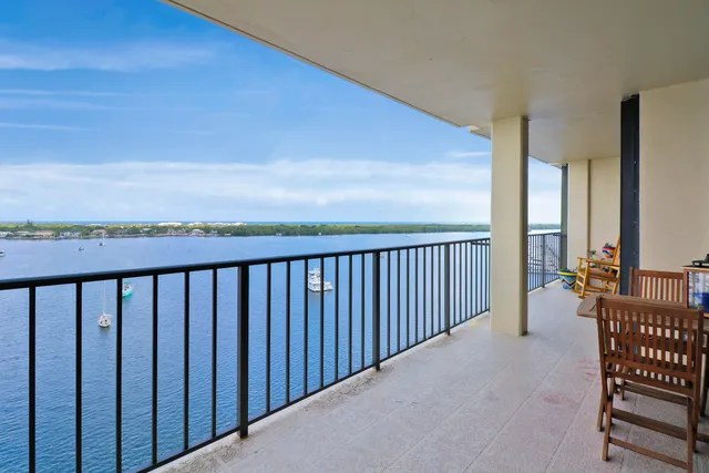 a living room with furniture large window and wooden floor