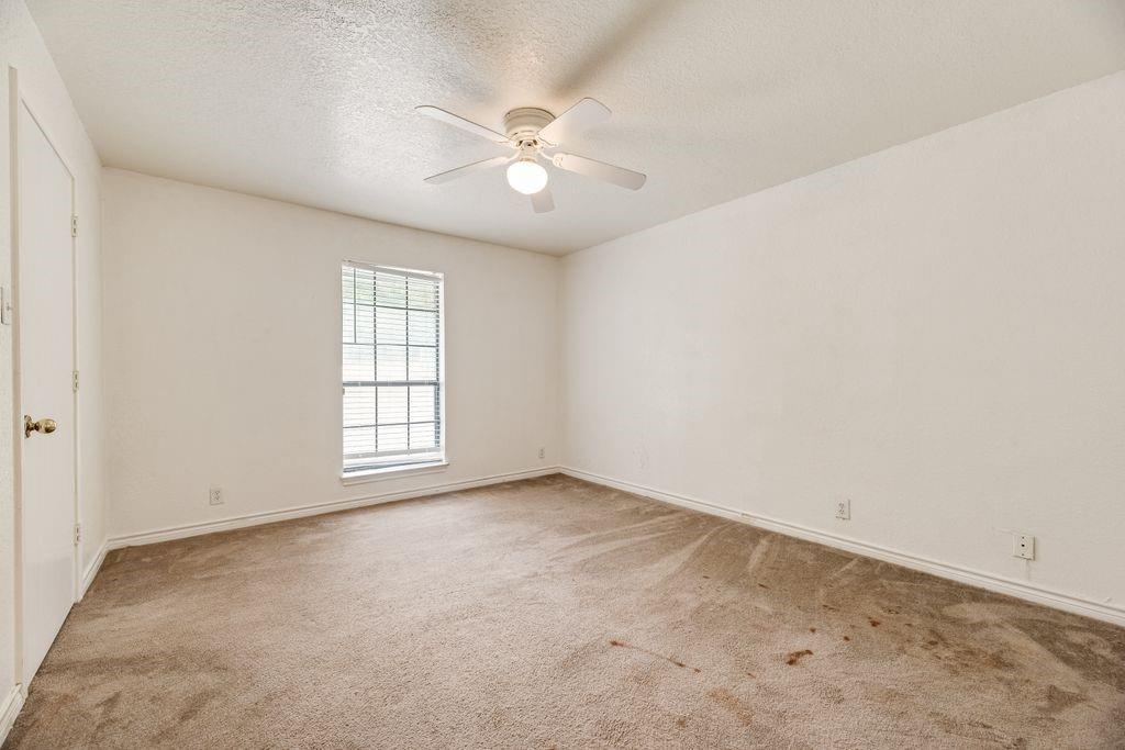 298 Butterfield Road Denison, TX 75021 - Photo 11 of 34 Spacious room featuring neutral carpeting, white walls, a single window with blinds, a white ceiling fan with integrated lighting, and a white interior door