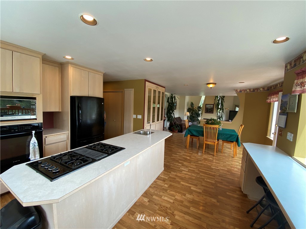 36103 Allen Road South Roy, WA 98580 - Photo 22 of 39 a kitchen with stainless steel appliances kitchen island granite countertop a table chairs and a refrigerator