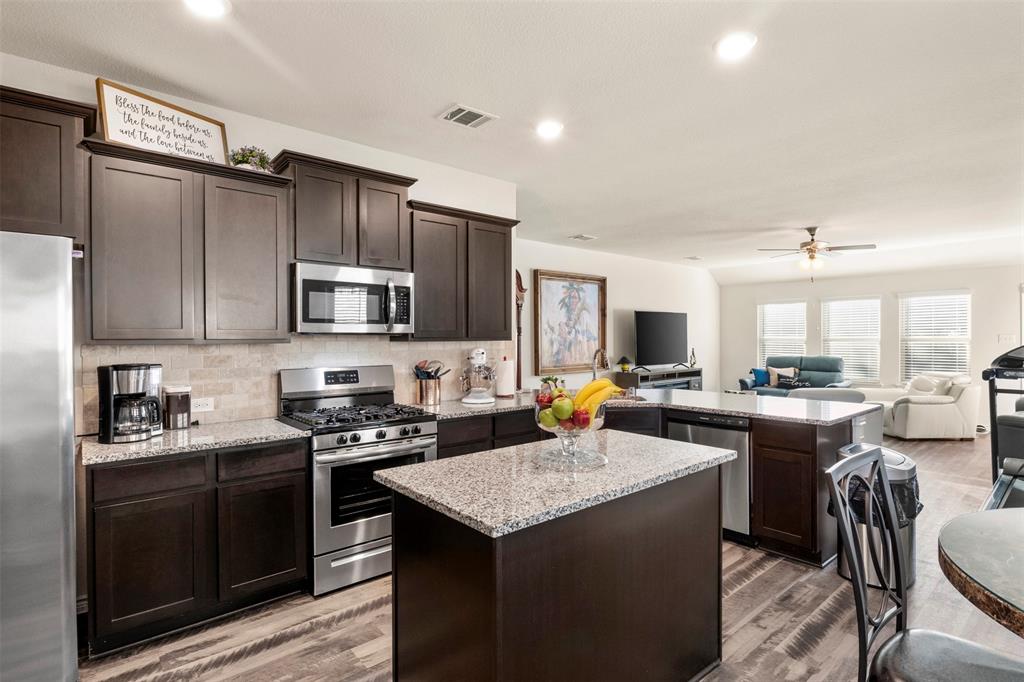 217 Watson Street Red Oak, TX 75154 - Photo 38 of 40 a kitchen with a stove a sink a dining table and chairs