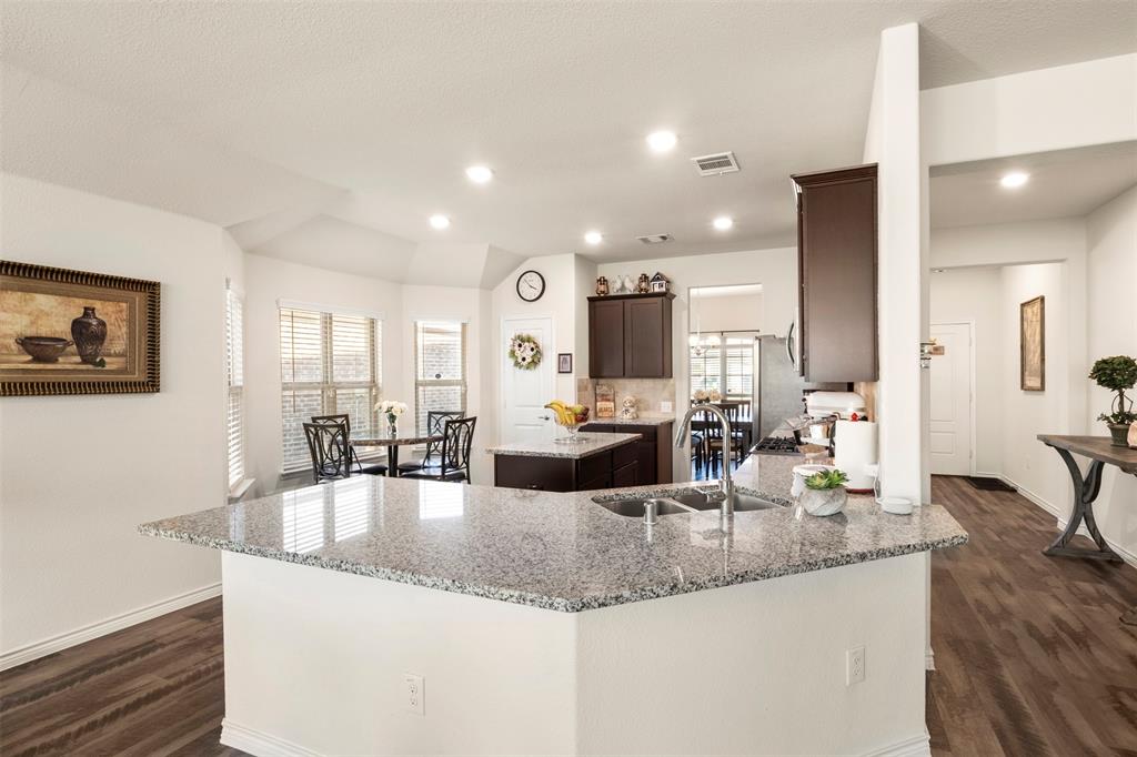217 Watson Street Red Oak, TX 75154 - Photo 18 of 40 a large kitchen with granite countertop a large counter top cabinets and living room view
