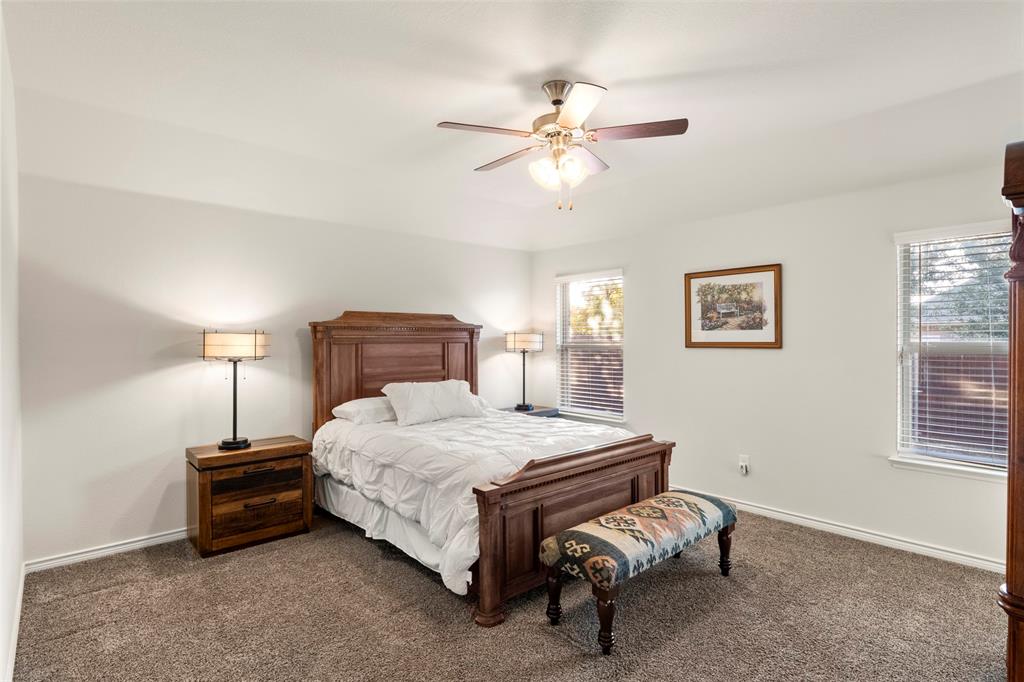 217 Watson Street Red Oak, TX 75154 - Photo 19 of 40 a bedroom with a bed and a chandelier