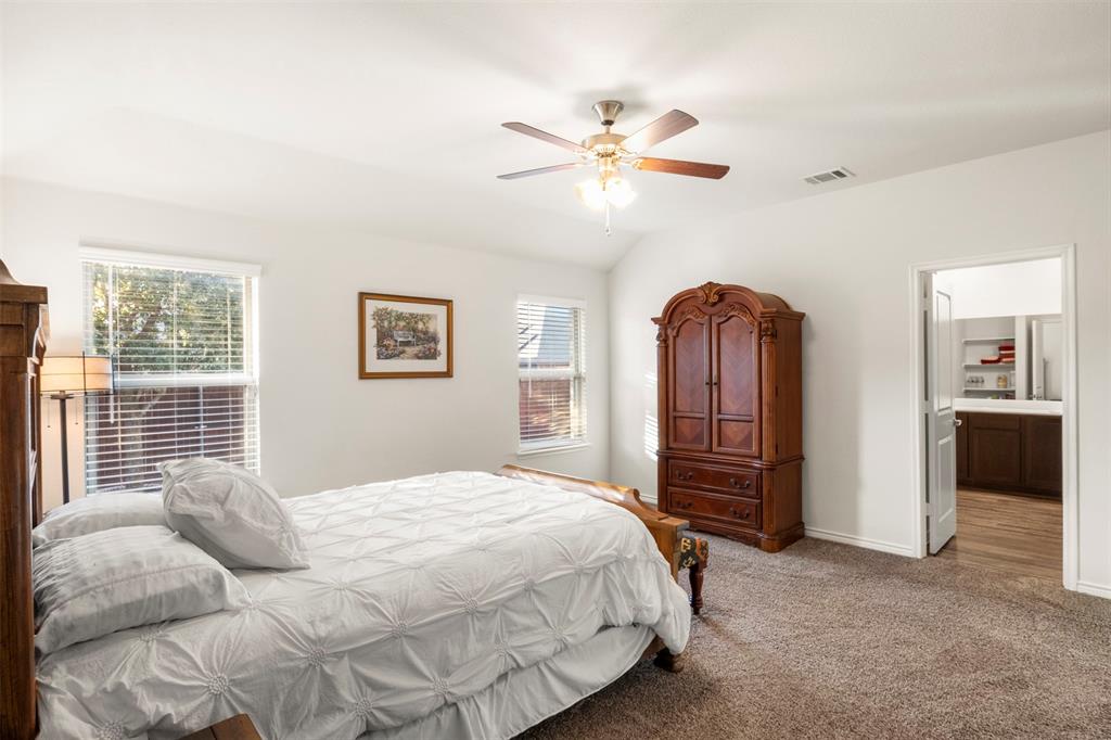 217 Watson Street Red Oak, TX 75154 - Photo 20 of 40 a bedroom with a large bed and a chandelier