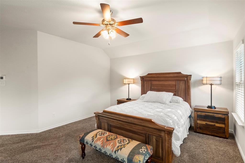 217 Watson Street Red Oak, TX 75154 - Photo 21 of 40 a bedroom with a bed and a chandelier