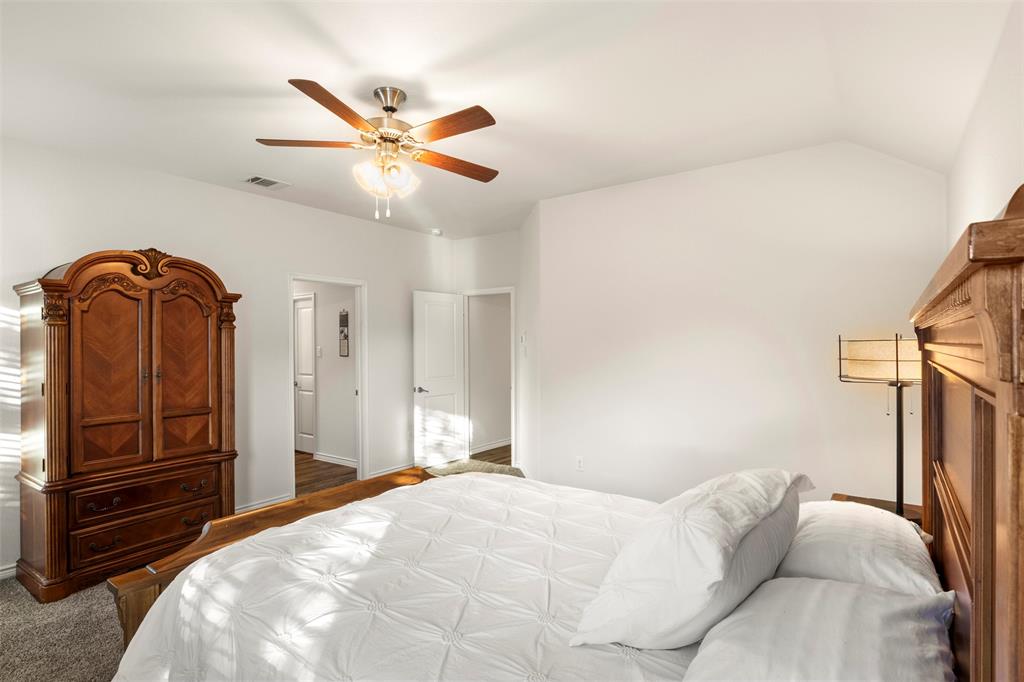217 Watson Street Red Oak, TX 75154 - Photo 22 of 40 a bedroom with a bed and dresser with wooden floor