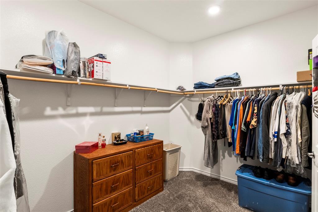 217 Watson Street Red Oak, TX 75154 - Photo 27 of 40 a view of walk in closet with clothes and shoes