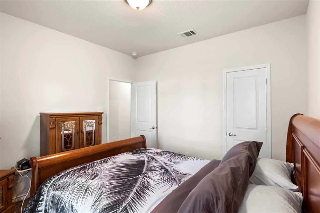 217 Watson Street Red Oak, TX 75154 - Photo 32 of 40 a bed sitting in a bedroom next to a window with pc on it