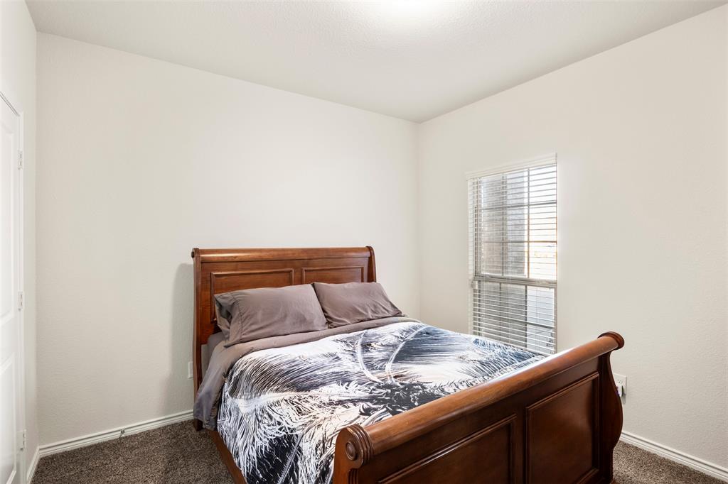 217 Watson Street Red Oak, TX 75154 - Photo 33 of 40 a bed sitting in a bedroom next to a window