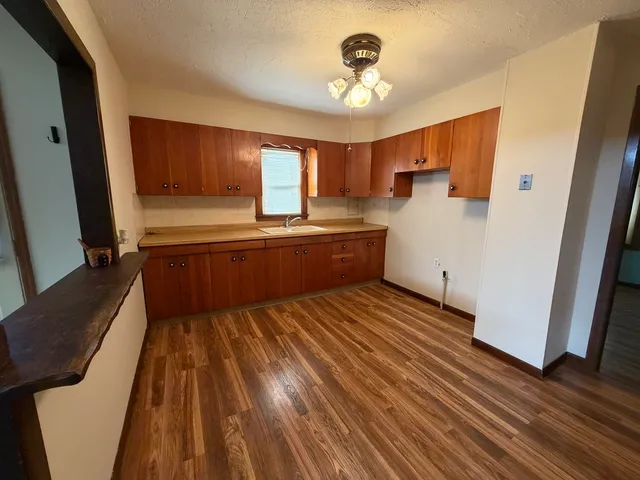 a large bedroom with a bed and wooden floor